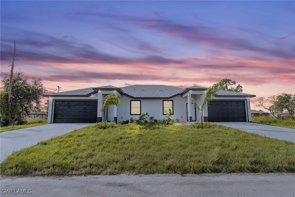 View of front of property with stucco siding, a ga