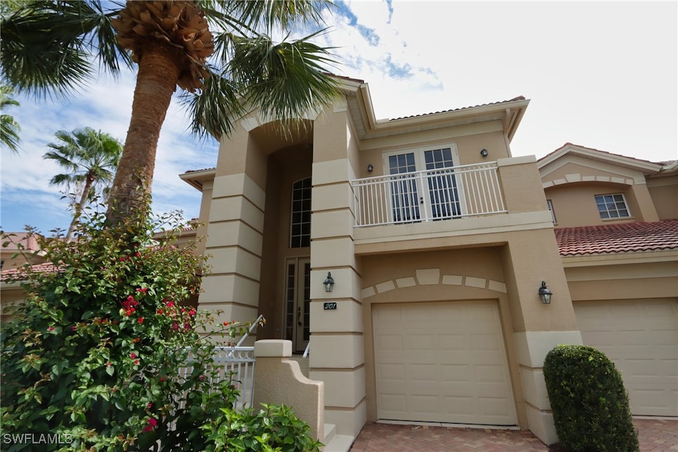 View of front of house with decorative driveway, an attached garage, a balcony, and stucco siding