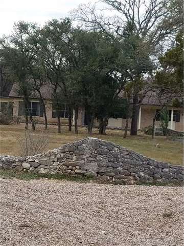 Front of the Property with a rock wall outlining t