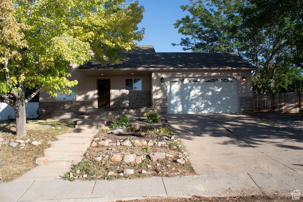 View of front of property with concrete driveway, an attached garage, brick siding, and roof with shingles