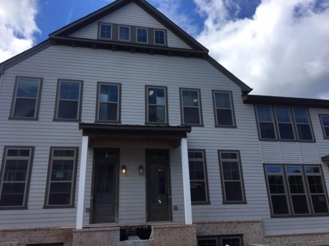 Exterior front of townhome. Large stacked windows,