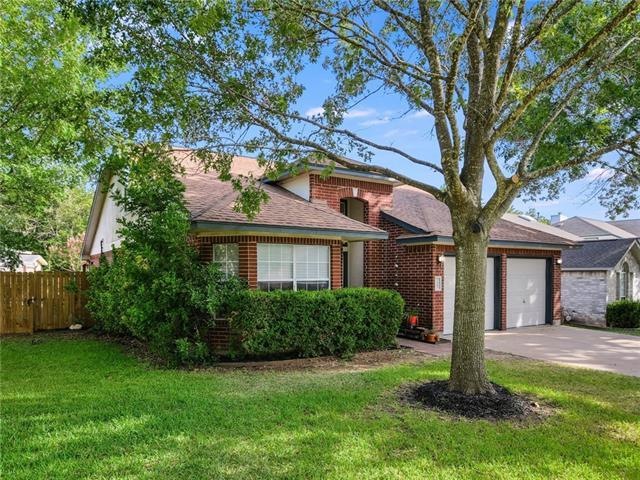 Landscaped yard with mature trees and sprinkler sy