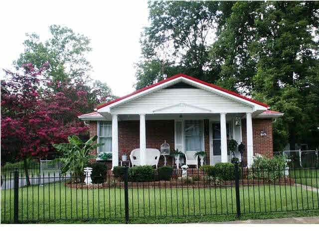 Sitting pretty  on a corner lot with a wrought iro