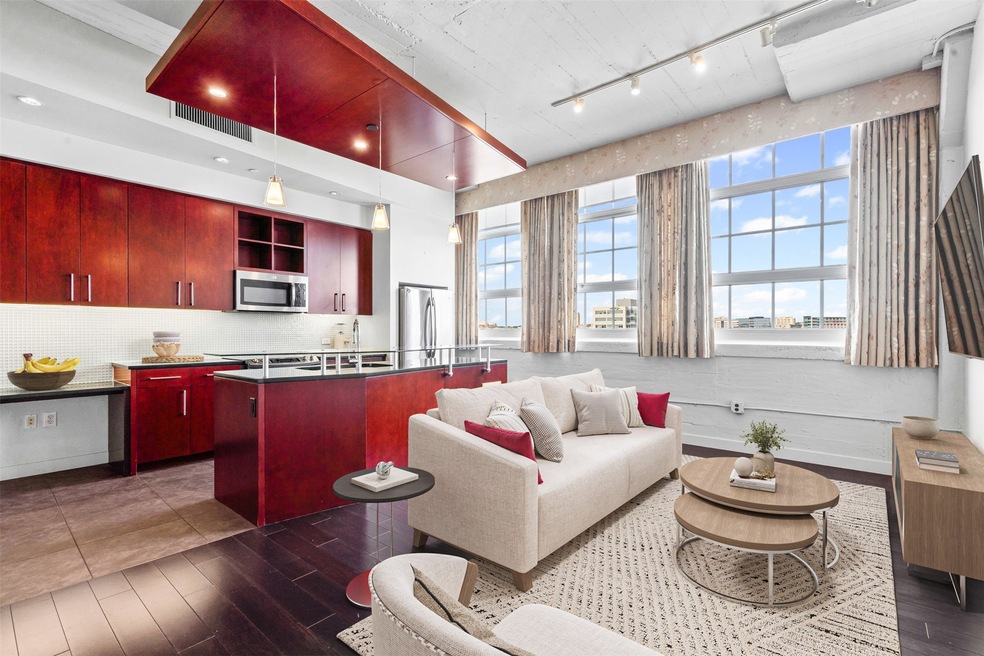Living room with rail lighting and dark wood-style flooring