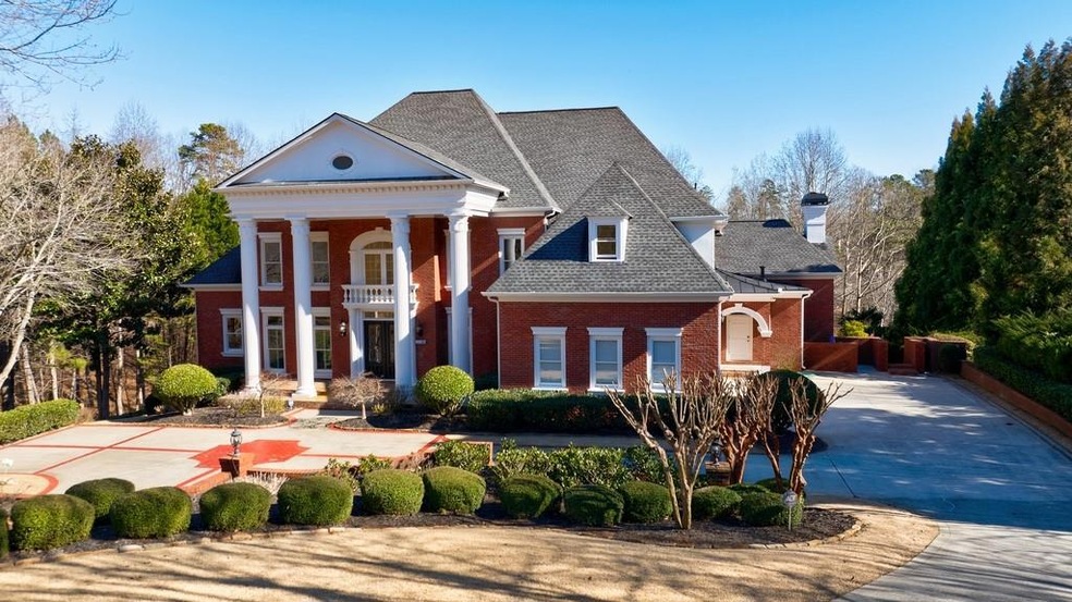 Greek revival house with a front lawn and a balcon