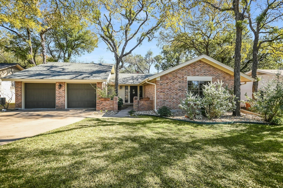 Ranch-style house featuring a front lawn, brick siding, concrete driveway, and an attached garage