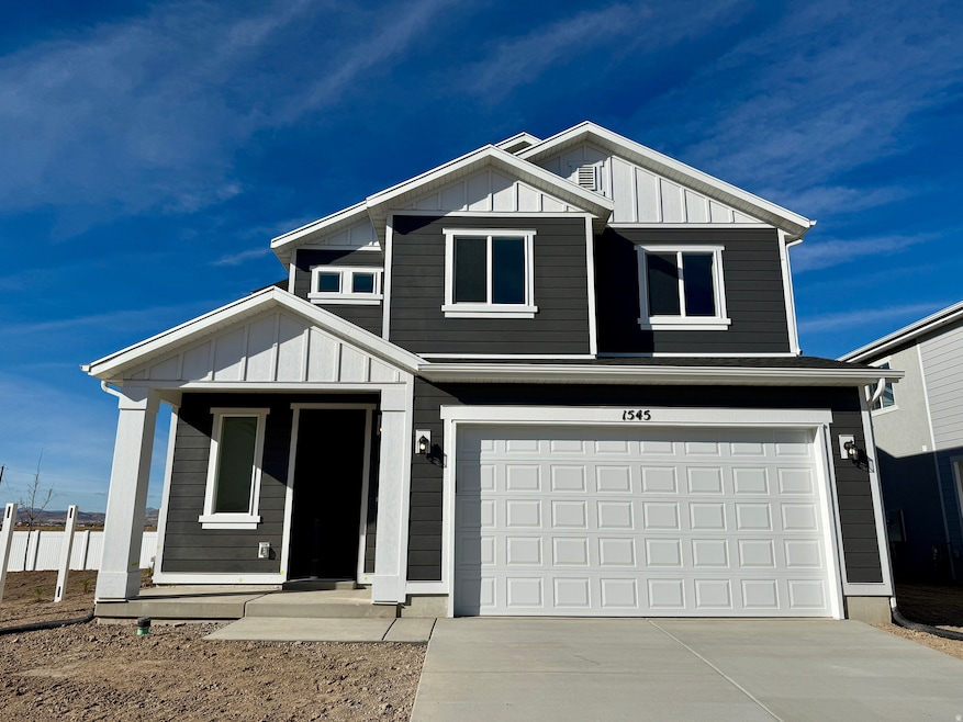 View of front facade featuring board and batten siding, an attached garage, and driveway