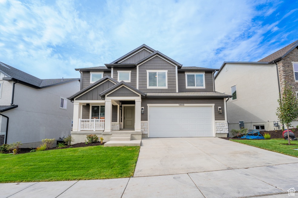 Craftsman inspired home with stone siding, board and batten siding, driveway, a front yard, and a porch