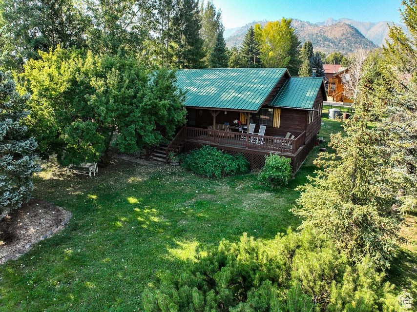view of house featuring a yard, metal roof, a mountain view, and stairway