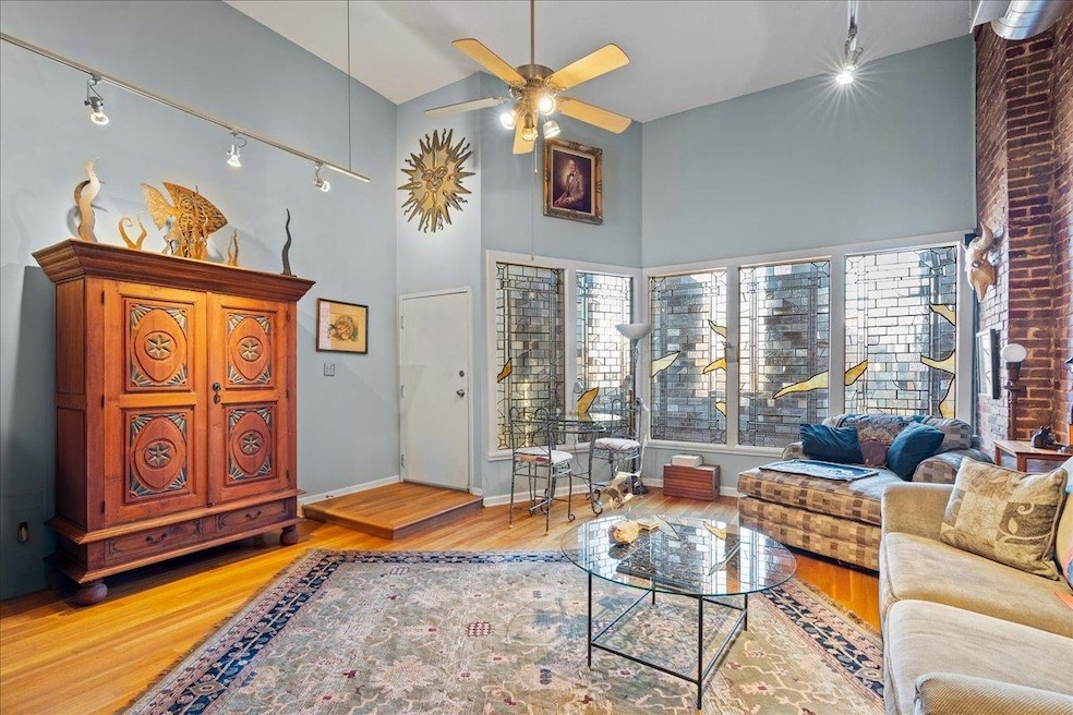 Living room featuring ceiling fan, a high ceiling,