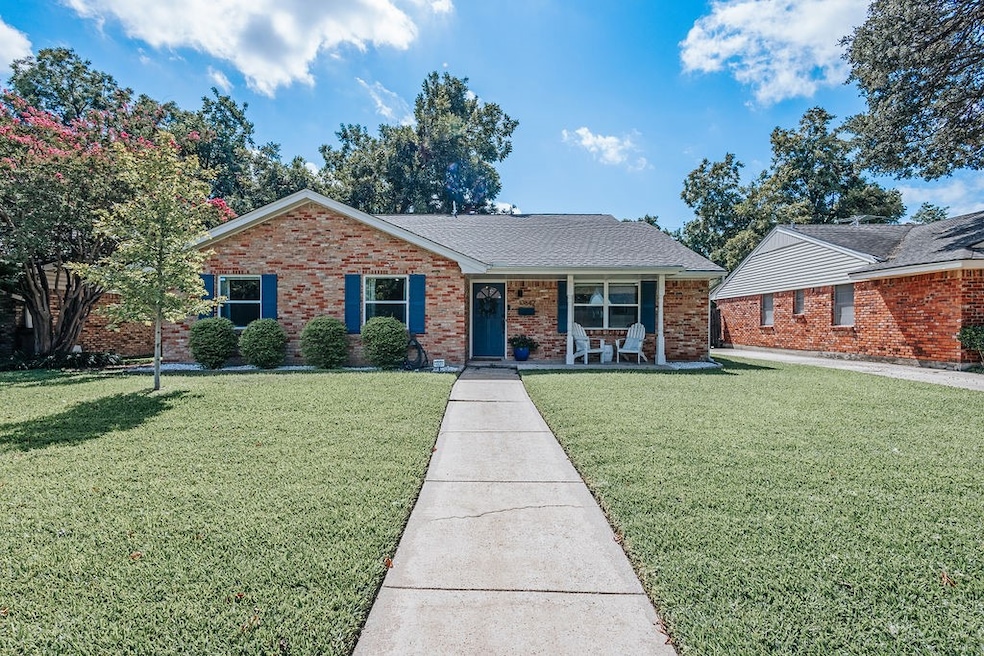 Single story home featuring a front yard, covered porch, and brick siding