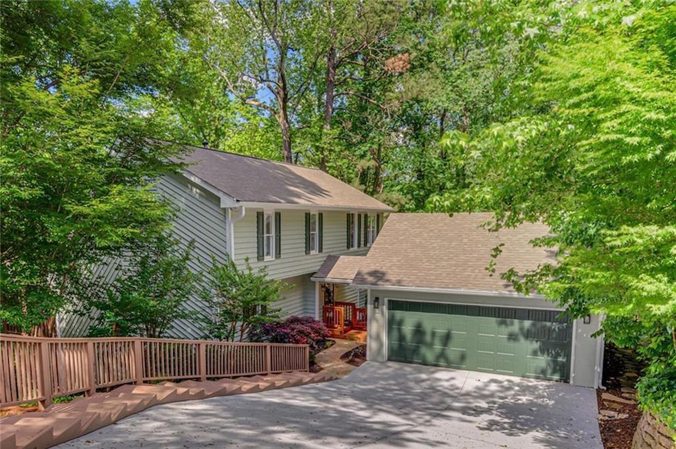View of front of property featuring concrete driveway, an attached garage, and a shingled roof