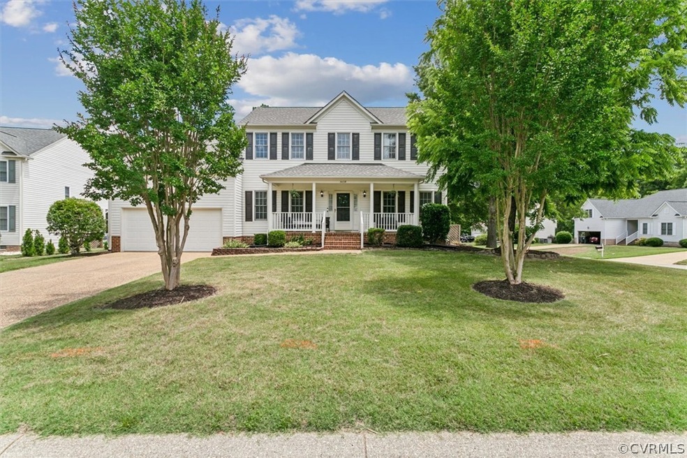 Colonial house featuring covered porch, a garage,