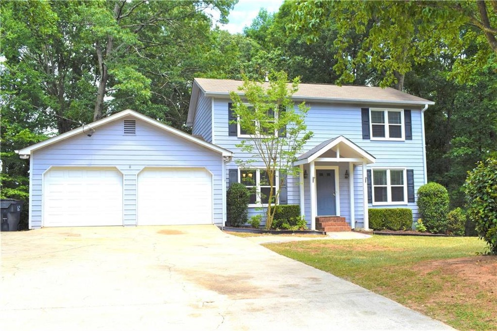 Colonial-style house with a garage and a front yar