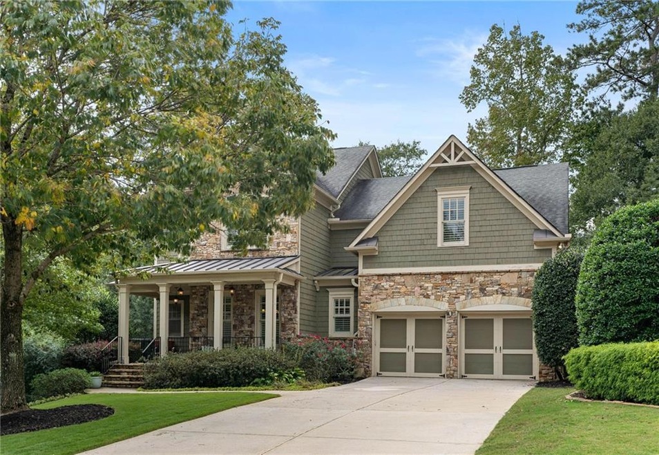 View of front of home with a garage, a porch, and 