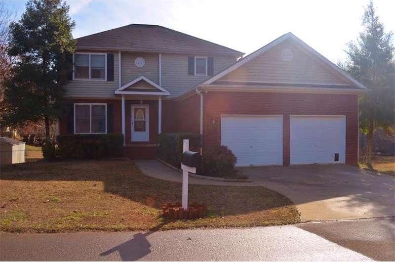 Front of home shows level beautiful corner lot wit