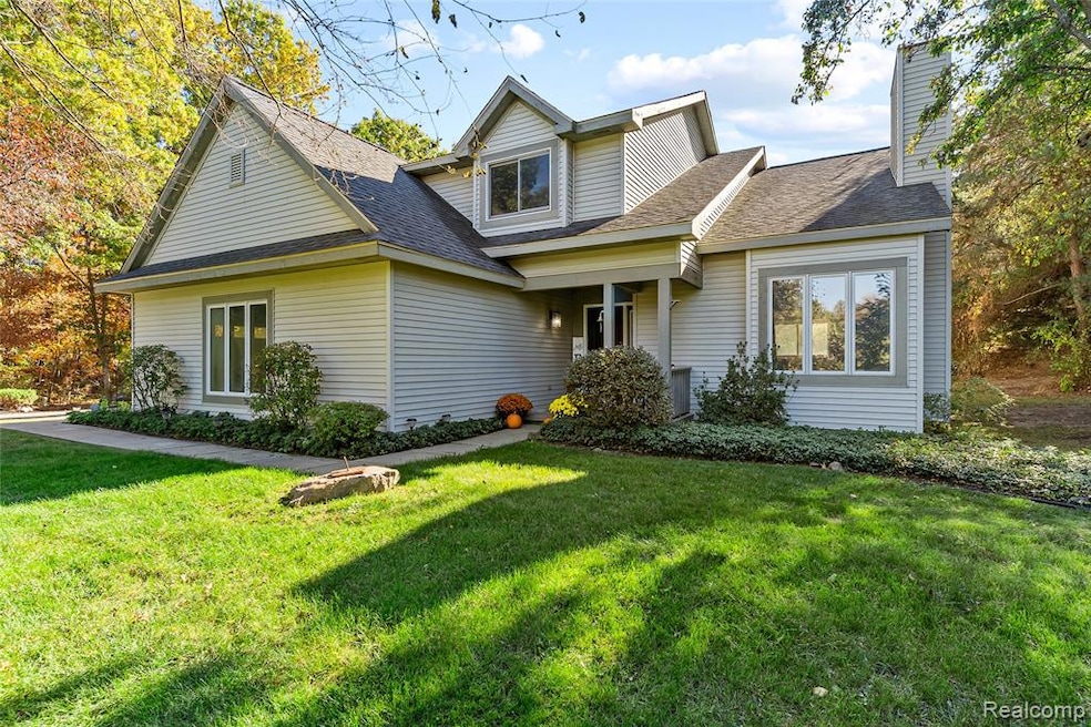 Traditional home featuring a front lawn, a shingled roof, and a chimney