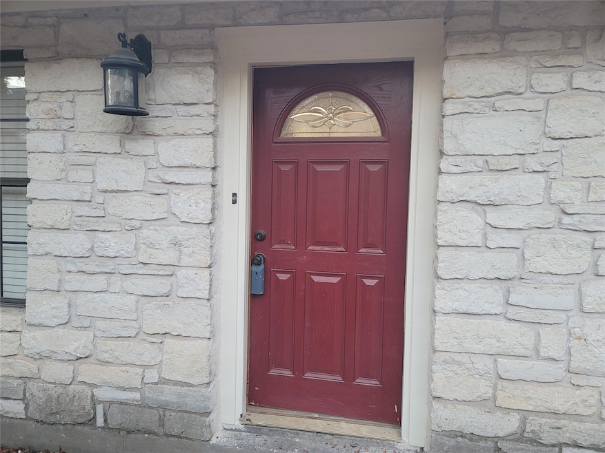 Doorway to property featuring stone siding