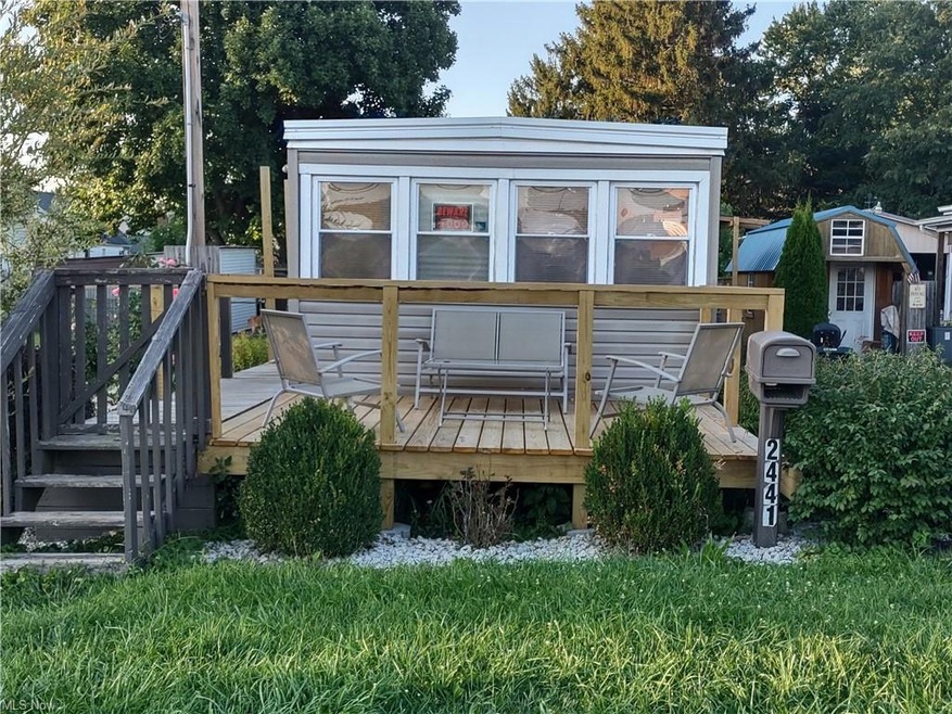 Front view of property featuring wooden deck