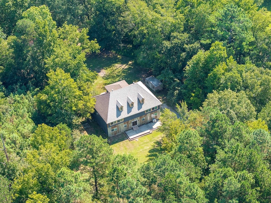 Aerial view of property and surrounding area featuring a heavily wooded area