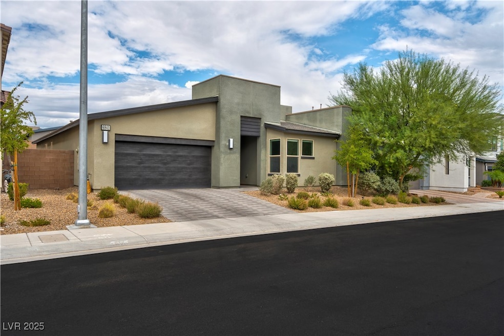 Contemporary house featuring stucco siding, decorative driveway, and a garage