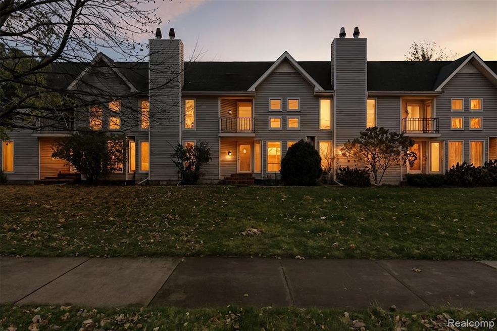 View of front facade featuring a chimney and a lawn