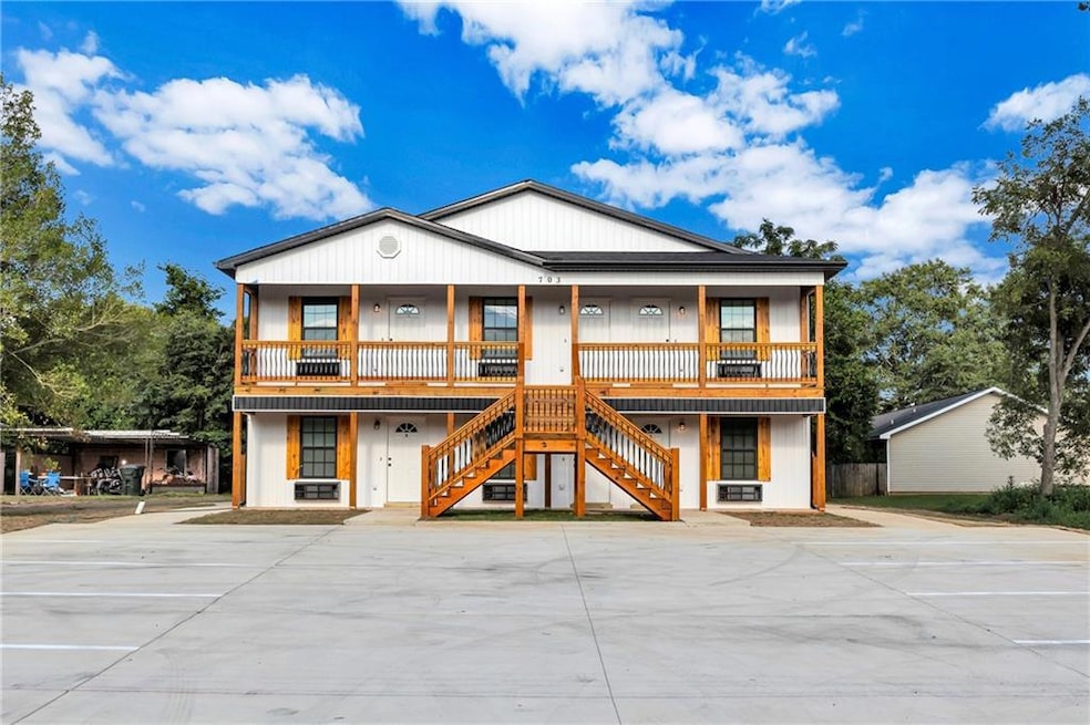 View of front of property with stairway and covered porch