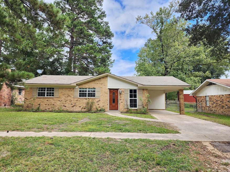 Ranch-style house with a carport and a front yard