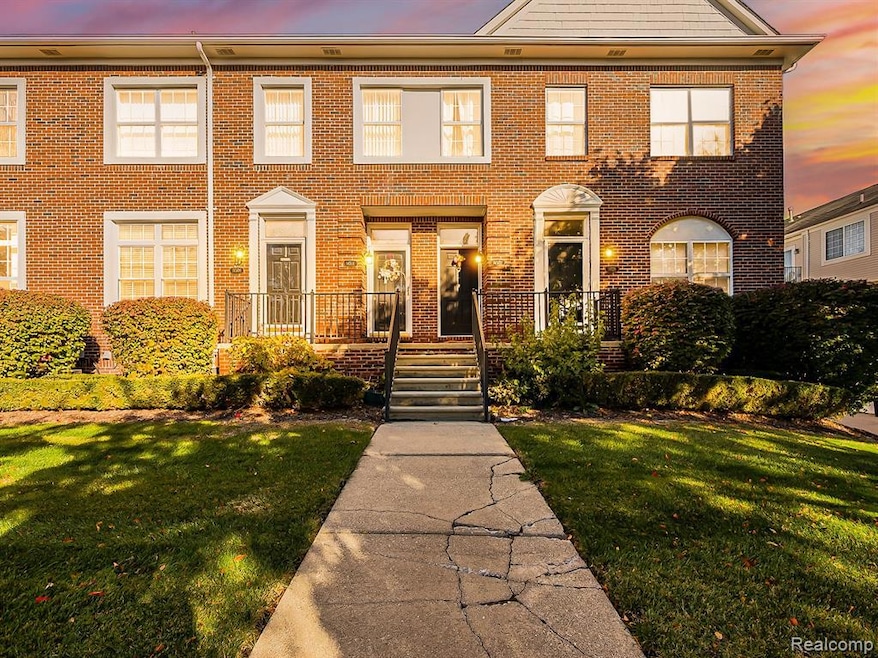 Colonial home with brick siding and a yard