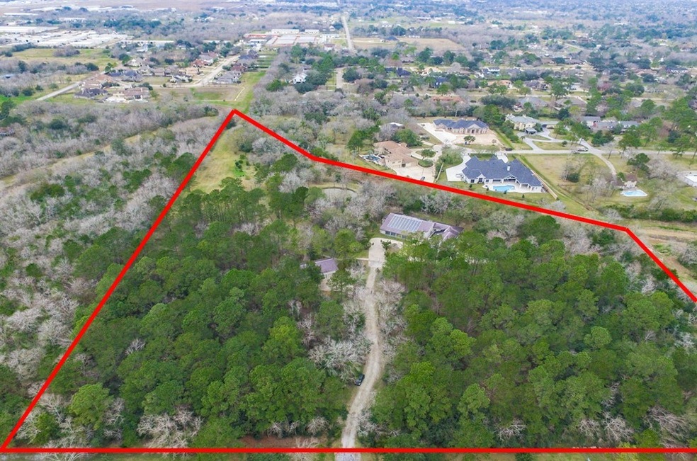 A slice of heaven in the heart of Friendswood!  Located in close proximity to Friendswood High School, this 11-acre wooded tract with a truly unique home also boasts an indoor swimming pool, a pond, a 2 hole golf course, and a producing citrus orchard!