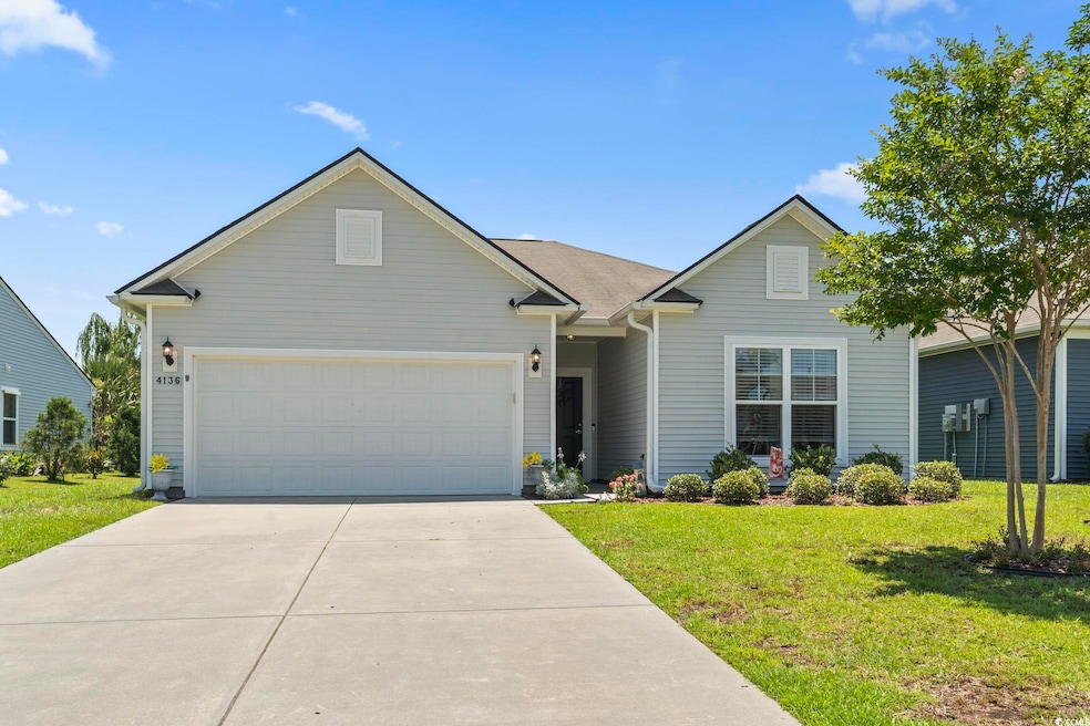 View of front facade featuring a front lawn, driveway, and an attached garage