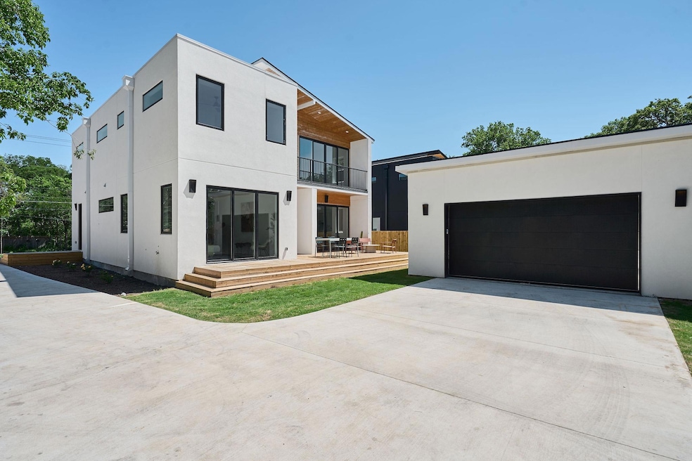Back of property with concrete driveway, stucco s