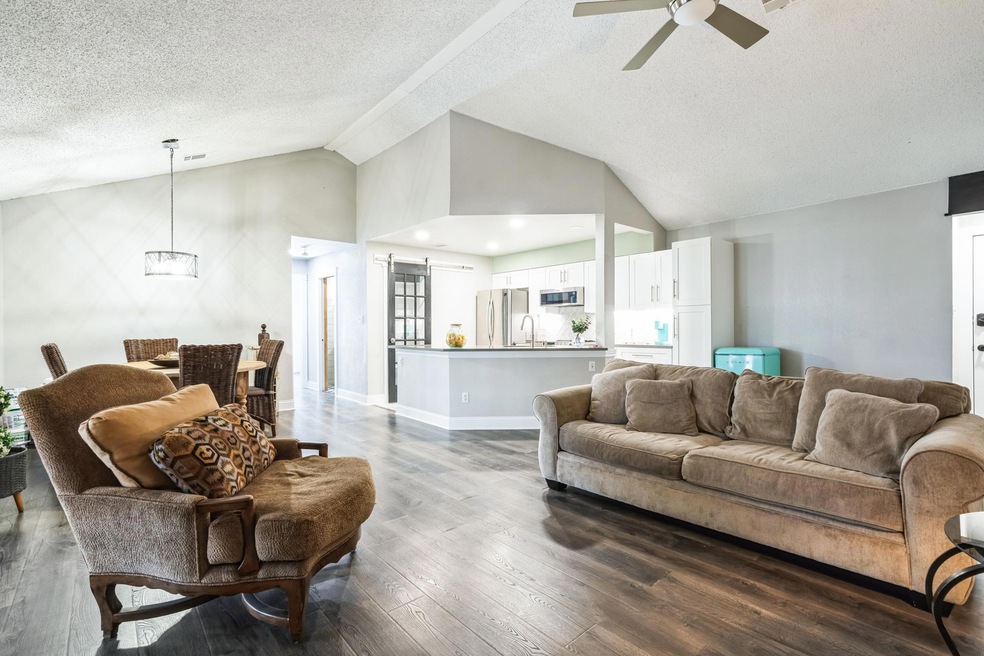 Living area featuring lofted ceiling, a textured 