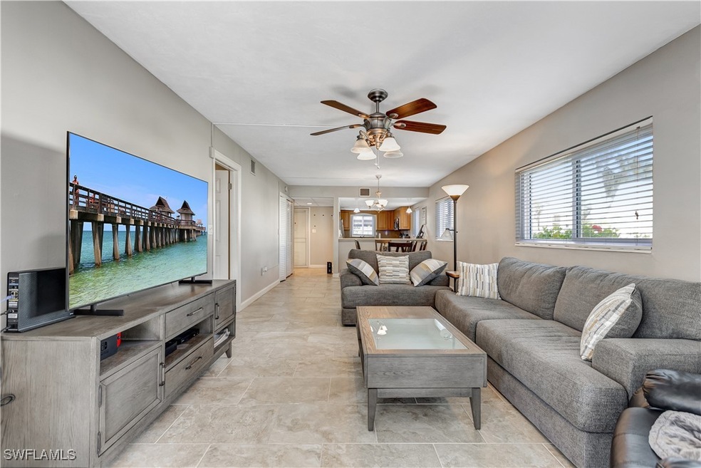 Living room featuring a ceiling fan, a chandelier,
