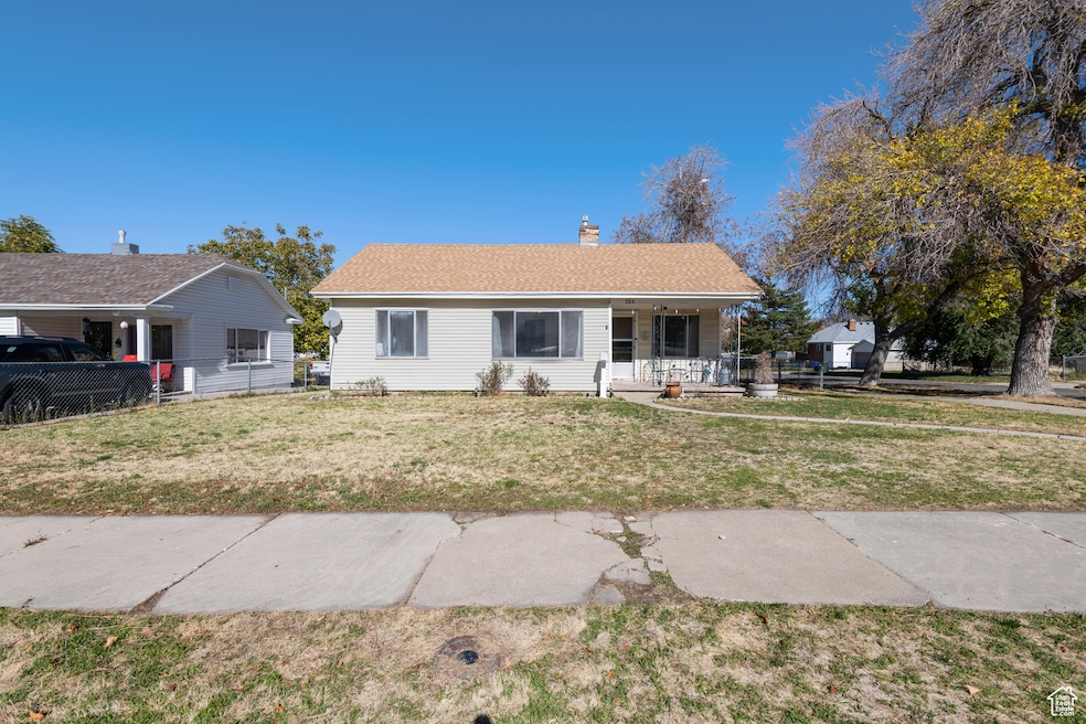 Ranch-style house featuring covered porch, a chimney, and roof with shingles