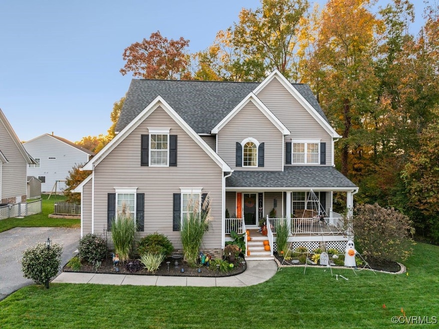 View of property with covered porch and a front ya