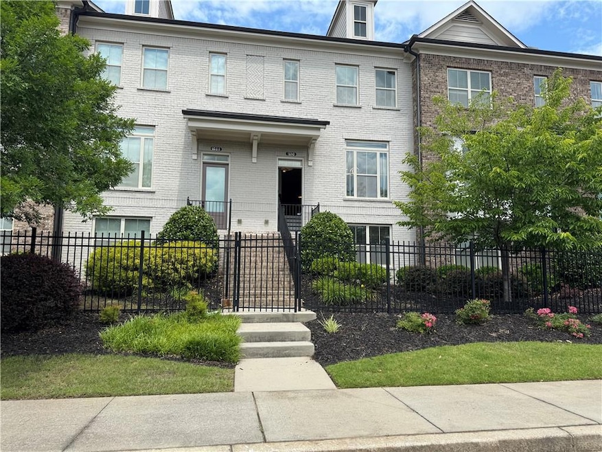 View of property featuring brick siding and a fenced front yard