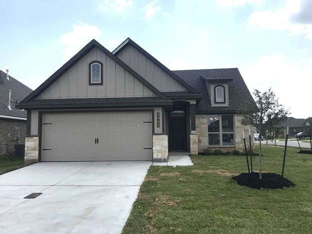 View of front of property featuring a garage, conc