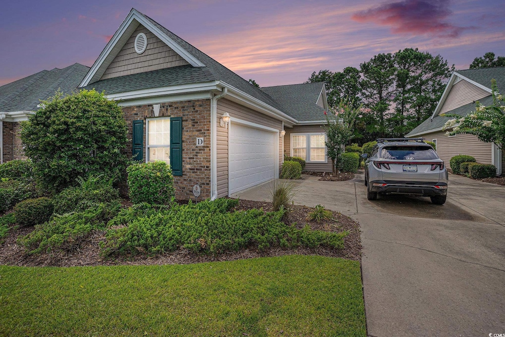 View of front of house with concrete driveway, brick siding, a shingled roof, a garage, and a lawn