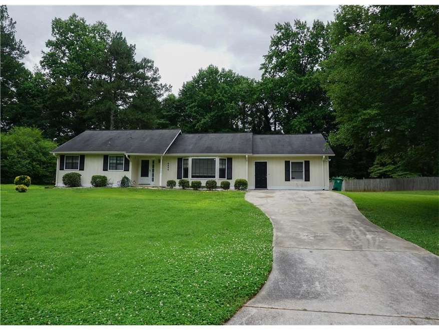 Long concrete driveway. Garage entry is a large bo