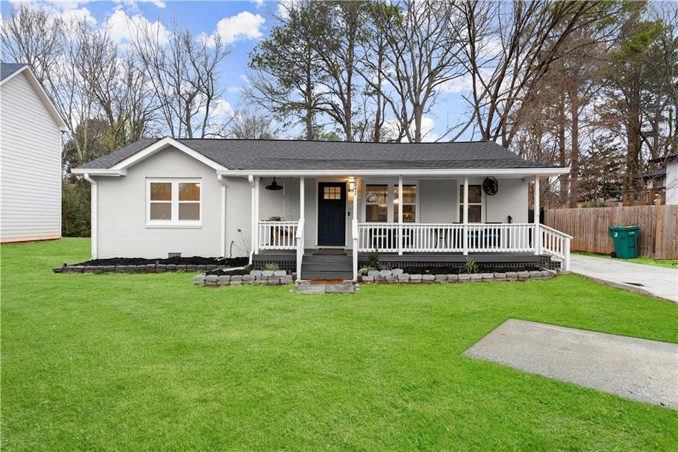 Single story home with covered porch, an additional parking pad, and brick siding