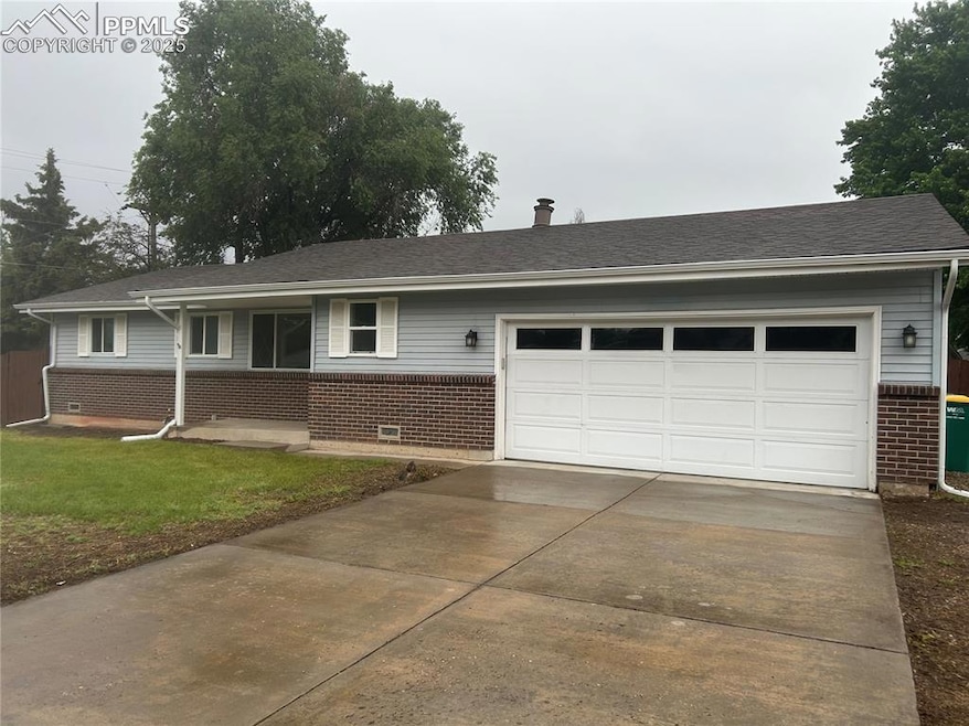 Single story home with brick siding, a garage, concrete driveway, roof with shingles, and a front lawn
