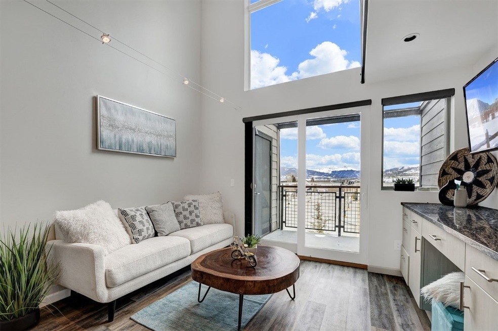 Bright, open living area featuring wood finished f