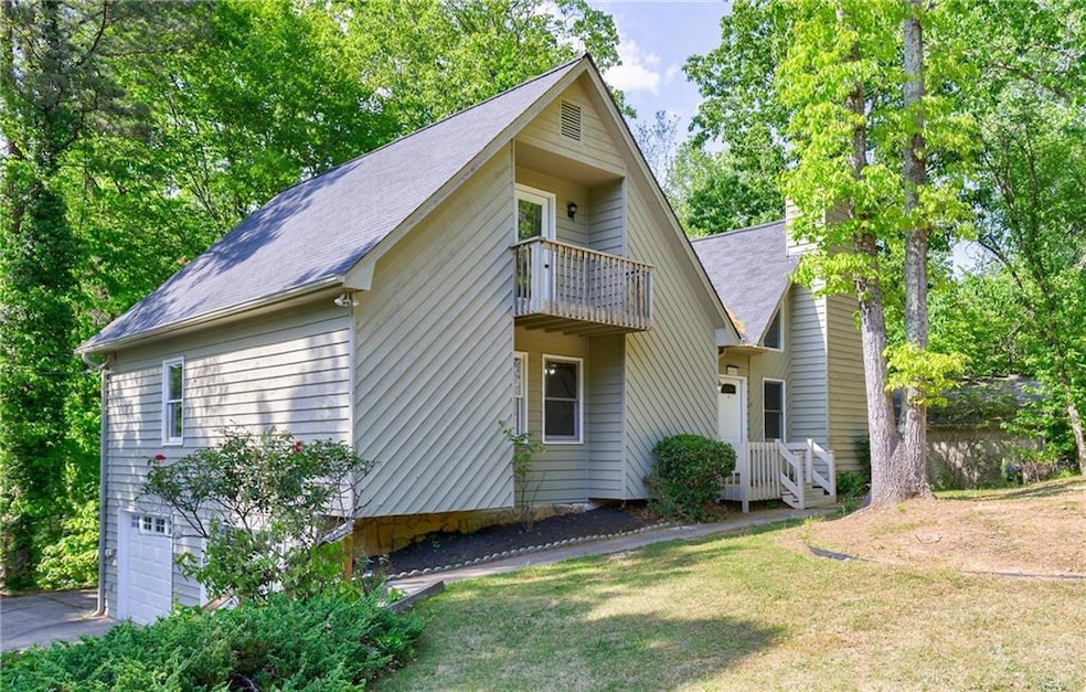View of front facade with a balcony, driveway, an 