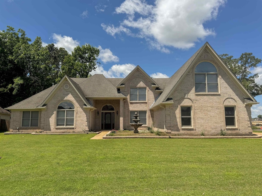 View of front of home featuring brick siding and a front yard