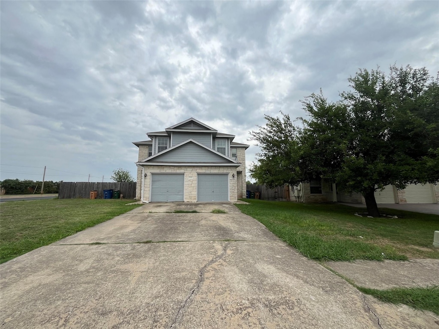 Traditional home with concrete driveway and stone