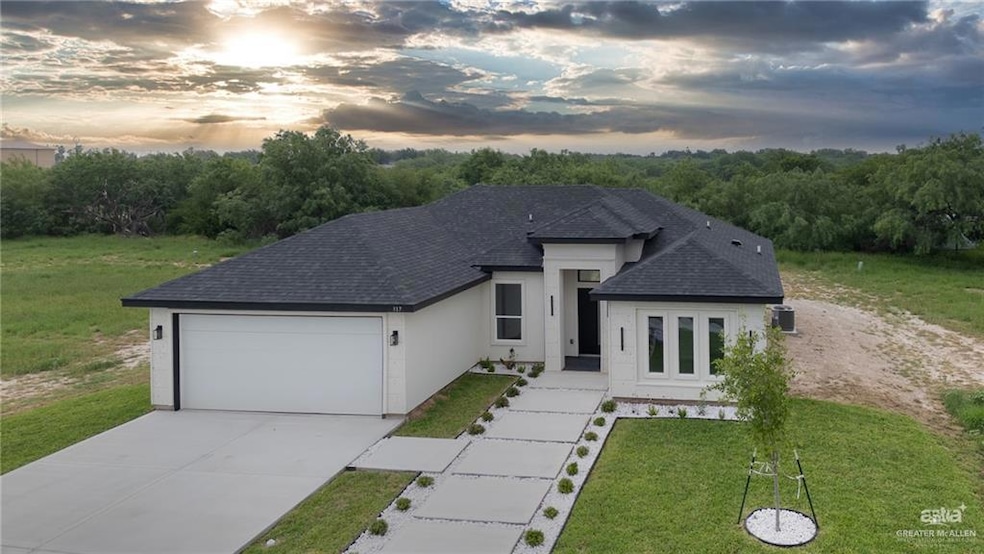 Single story home with concrete driveway, a lawn, a shingled roof, and an attached garage