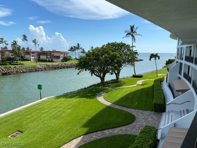 View of community with a water view and a yard