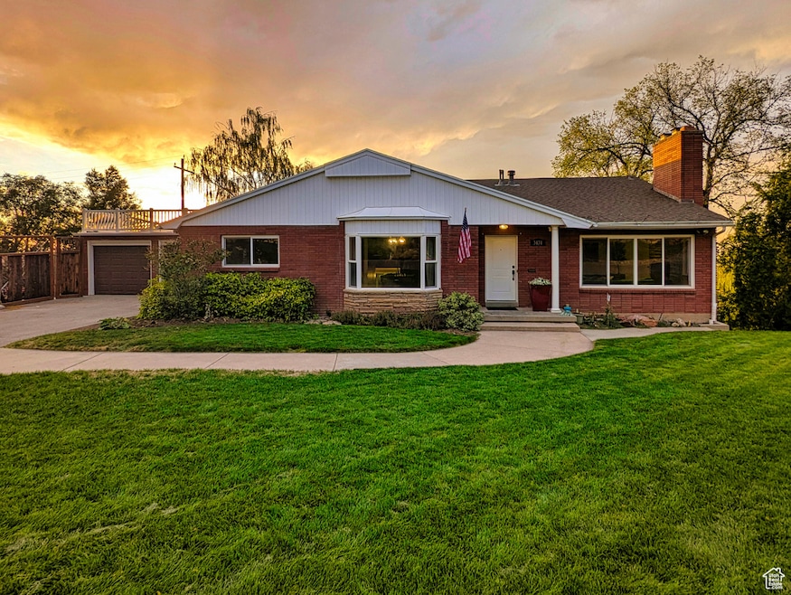 View of front of home featuring brick siding, a front yard, and concrete driveway