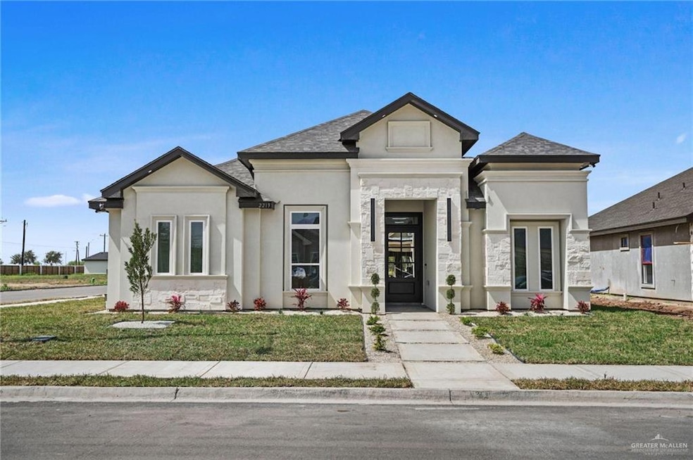 View of front of property with stone siding, a front yard, and stucco siding